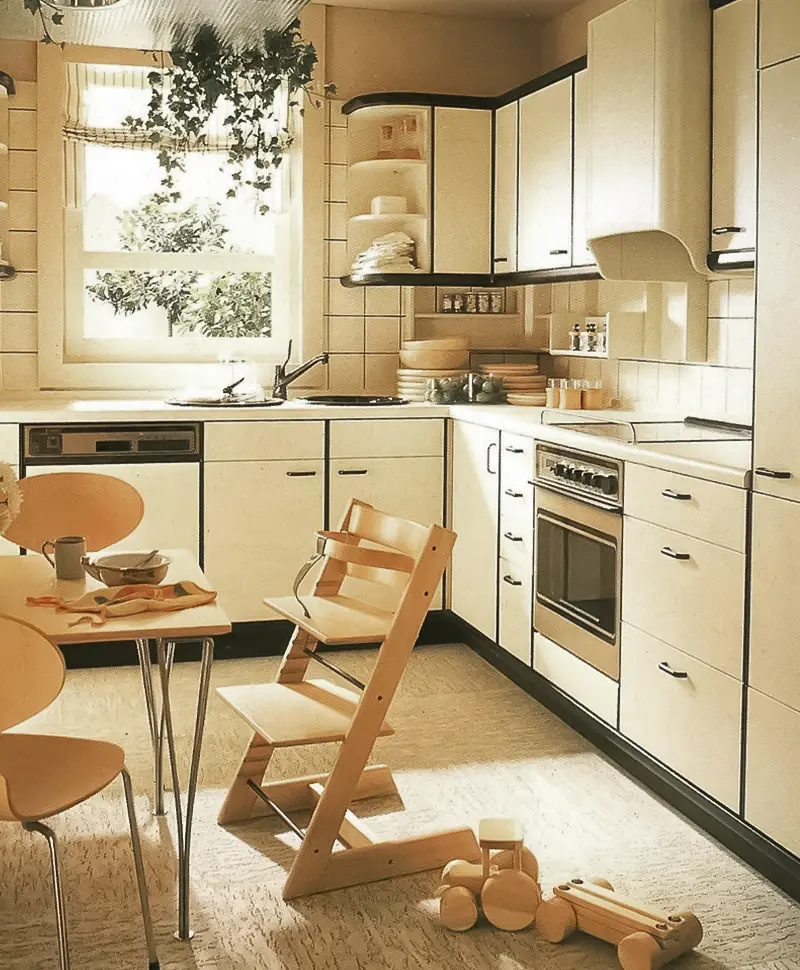 cocina de los años 80 con muebles blancos con ribete negro mesa pequeña para comer con sillas de metal y madera