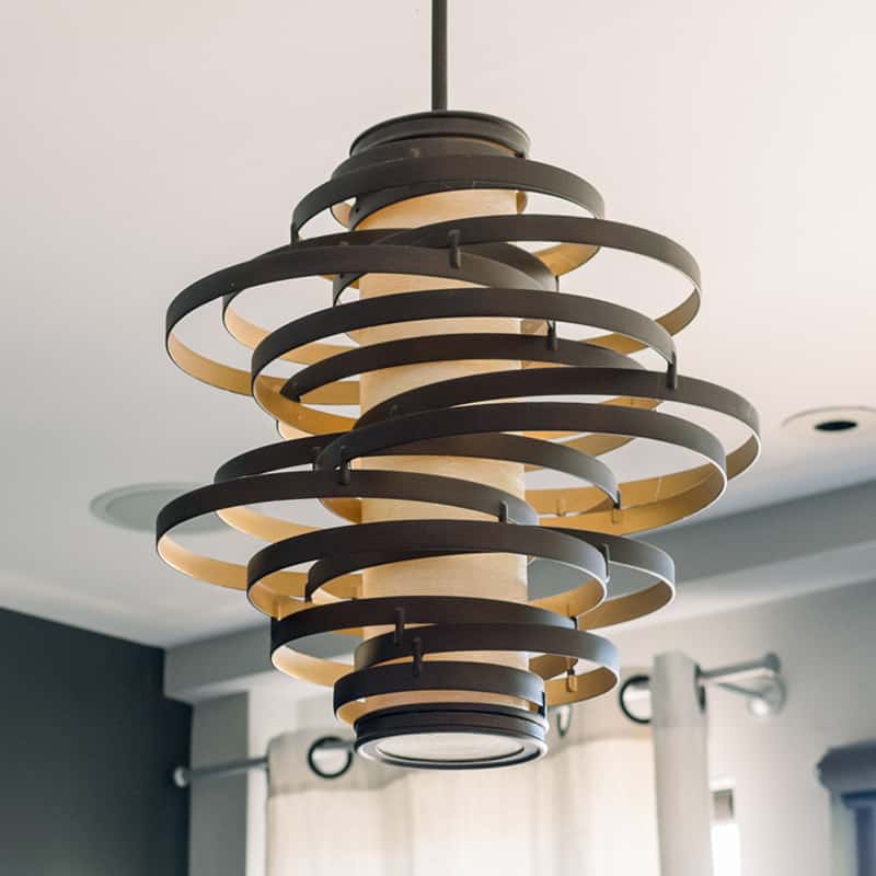 Lámpara moderna decorada con cintas horizontales en forma de círculo en posiciones variadas colgada del techo 